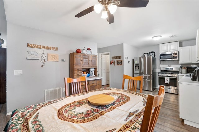 dining room featuring wood-type flooring and ceiling fan