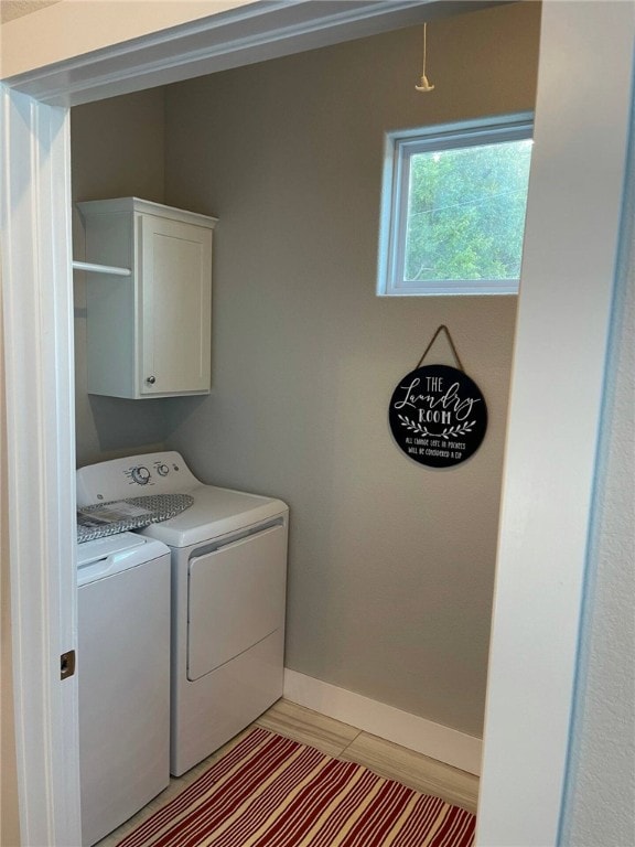 laundry room featuring washing machine and dryer and cabinets