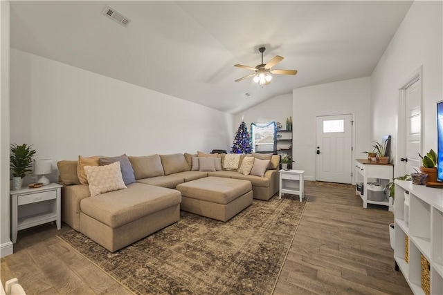 living room featuring ceiling fan, dark hardwood / wood-style flooring, and vaulted ceiling