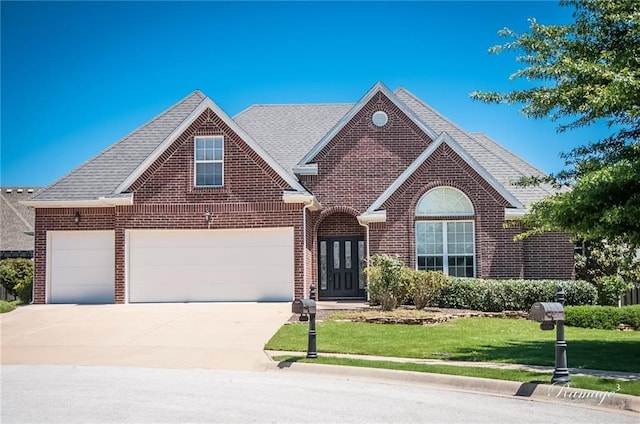 view of front of property featuring a front yard and a garage