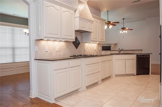 kitchen featuring stainless steel gas stovetop, sink, white cabinetry, and black dishwasher