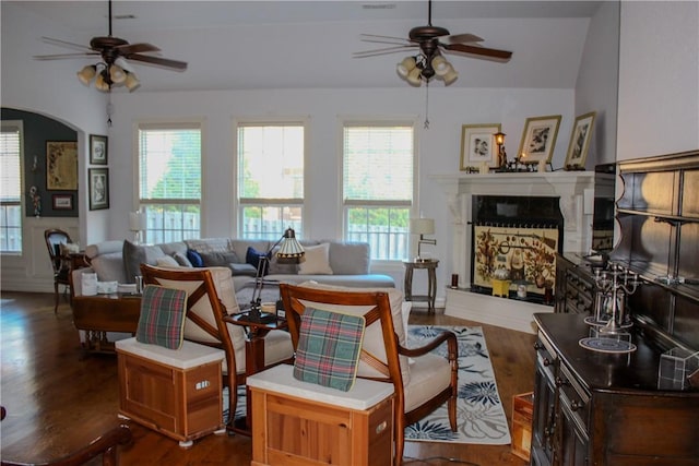 living room featuring dark wood-type flooring, a wealth of natural light, lofted ceiling, and ceiling fan