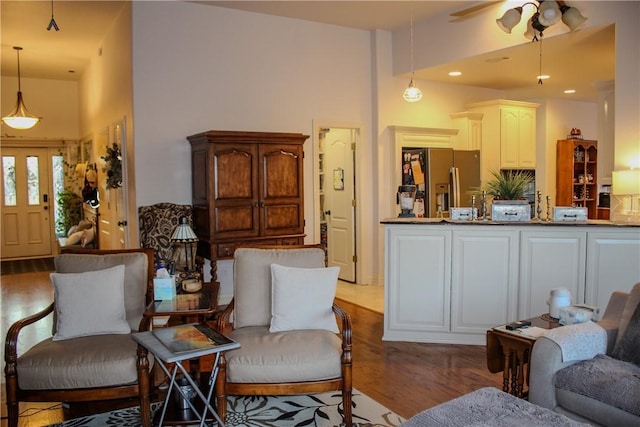 living room featuring a towering ceiling, dark hardwood / wood-style floors, and ceiling fan