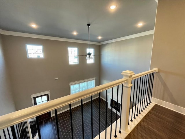 staircase featuring ceiling fan, wood-type flooring, and ornamental molding