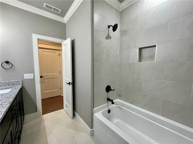 bathroom featuring tile patterned flooring, vanity, ornamental molding, and tiled shower / bath