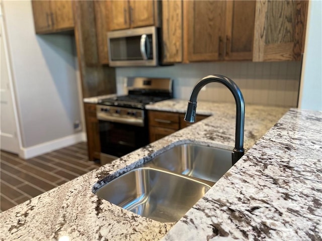 kitchen featuring light stone countertops, sink, and white gas range oven