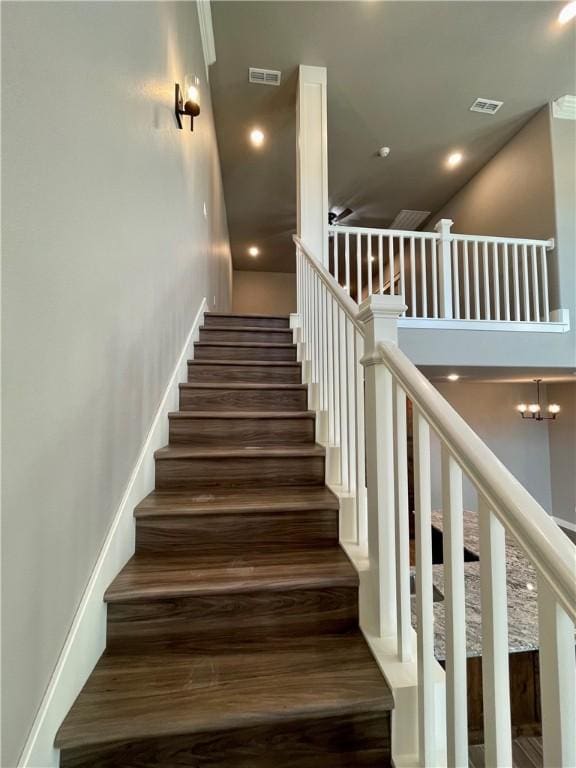 staircase with a chandelier and hardwood / wood-style flooring