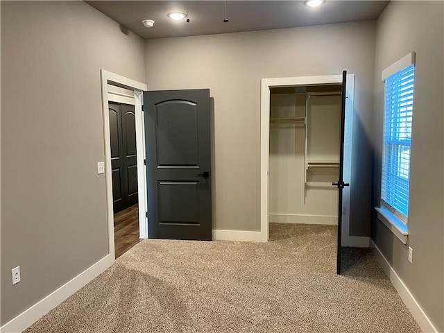 unfurnished bedroom featuring carpet flooring and a closet