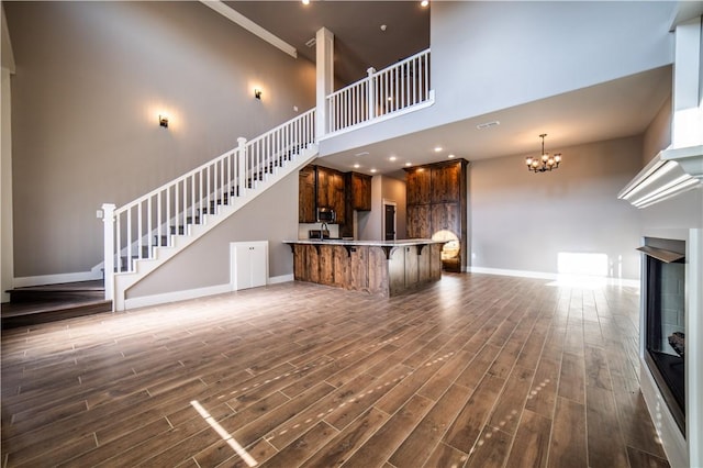 unfurnished living room featuring a notable chandelier and a high ceiling