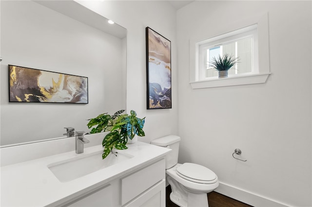 bathroom with hardwood / wood-style floors, vanity, and toilet