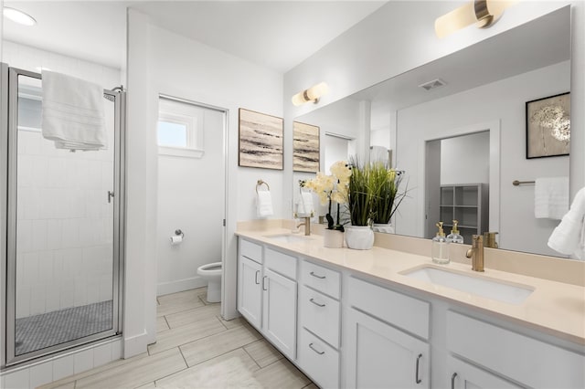 bathroom featuring vanity, toilet, and an enclosed shower