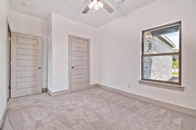 unfurnished bedroom featuring a closet, light colored carpet, and ceiling fan