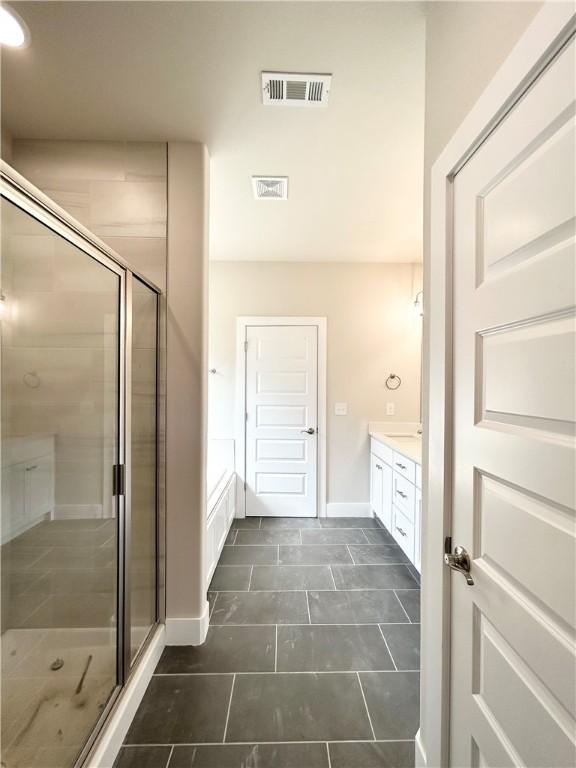 bathroom featuring tile patterned flooring, vanity, and a shower with shower door