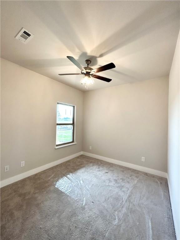 carpeted spare room with ceiling fan