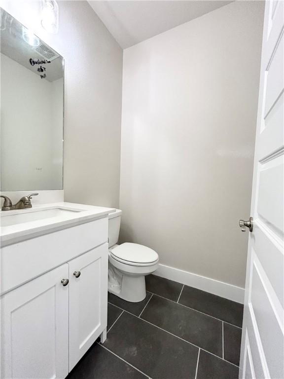 bathroom with tile patterned flooring, vanity, and toilet