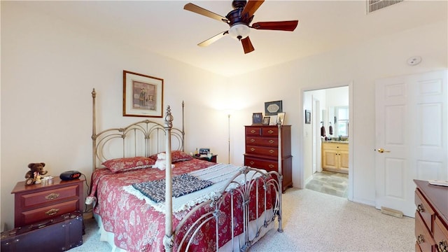 bedroom with ceiling fan, light carpet, and connected bathroom