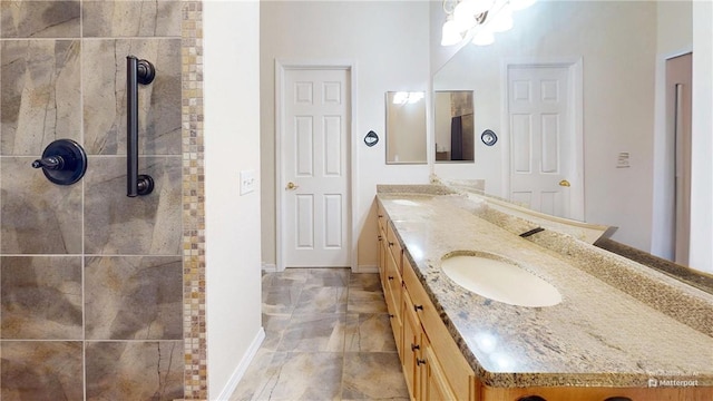 bathroom with tiled shower and vanity