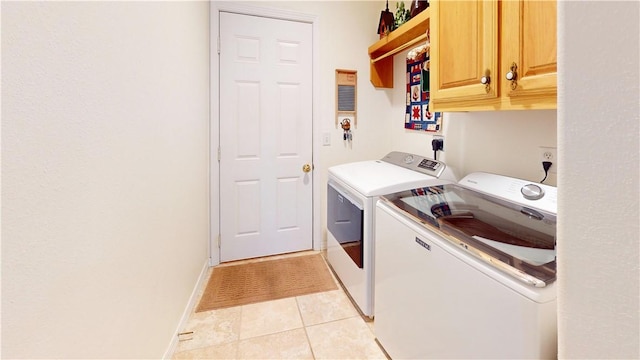 laundry area featuring light tile patterned flooring, cabinets, and independent washer and dryer