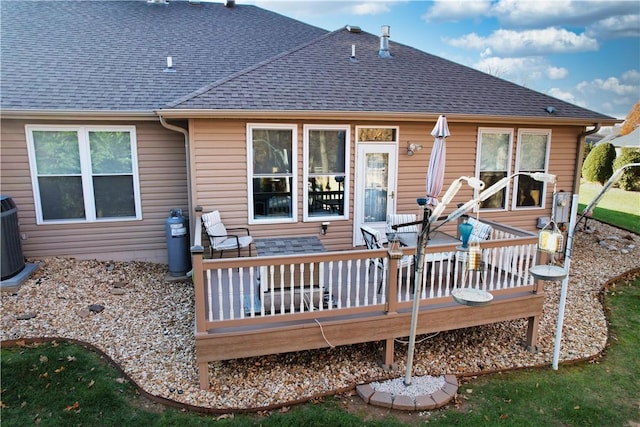 rear view of property featuring central AC and a wooden deck