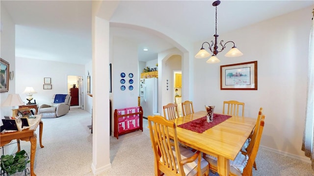 carpeted dining space featuring a notable chandelier