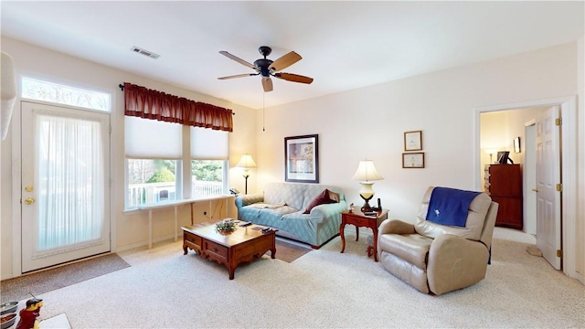 living room featuring light colored carpet and ceiling fan