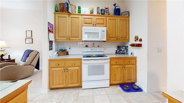 kitchen with light tile patterned flooring, white appliances, and tasteful backsplash