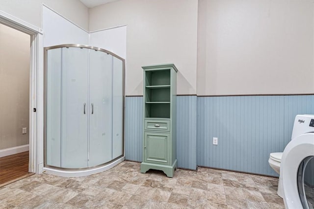 1395 County Road 403, Berryville, AR 72616 - bathroom featuring a stall shower, washer / clothes dryer, wainscoting, and stone finish flooring