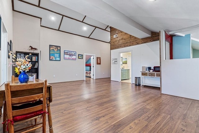 living room with vaulted ceiling with beams and wood-type flooring