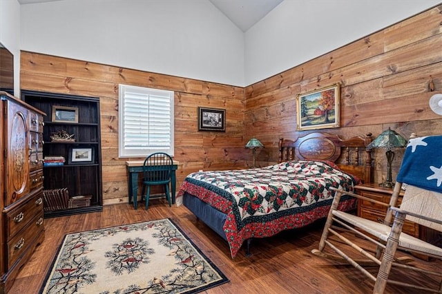 bedroom featuring wood walls, lofted ceiling, and hardwood / wood-style flooring