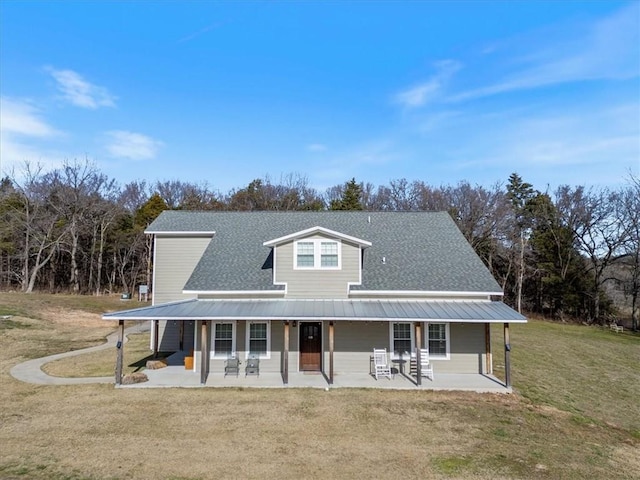 1395 County Road 403, Berryville, AR 72616 - country-style home featuring a front lawn, a metal roof, covered porch, roof with shingles, and view of wooded area