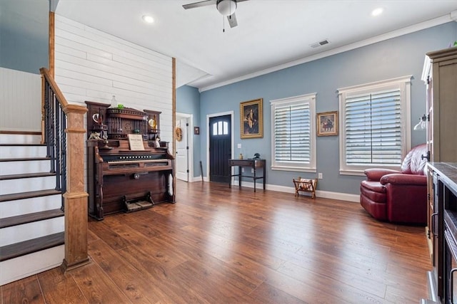 interior space with ceiling fan, dark hardwood / wood-style floors, and ornamental molding