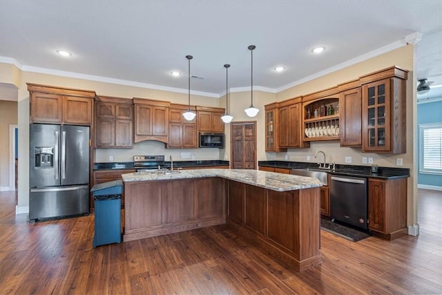 kitchen featuring sink, hanging light fixtures, dark stone counters, a center island with sink, and appliances with stainless steel finishes