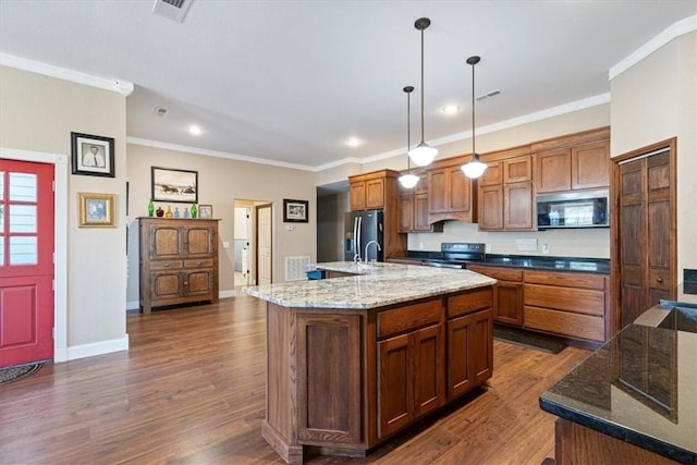 kitchen with decorative light fixtures, ornamental molding, an island with sink, and stainless steel appliances