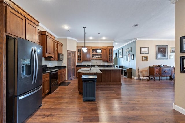 kitchen featuring light stone countertops, hanging light fixtures, crown molding, a kitchen island with sink, and black appliances