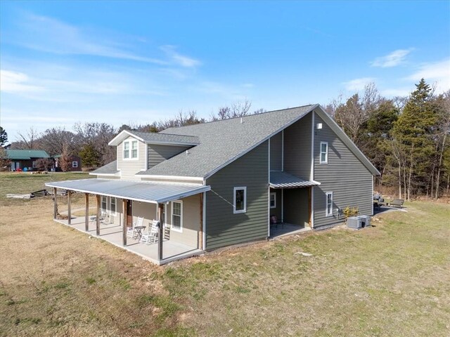 1395 County Road 403, Berryville, AR 72616 - view of property exterior with a lawn, roof with shingles, and a patio