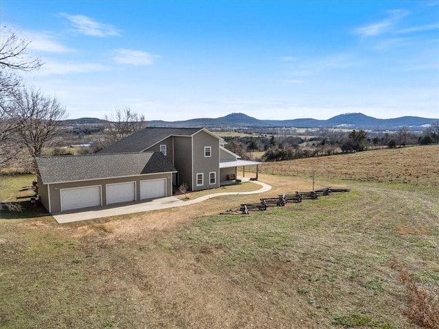 exterior space featuring a mountain view, a yard, and a garage