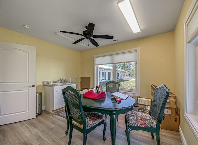 dining room with ceiling fan, sink, and light hardwood / wood-style floors