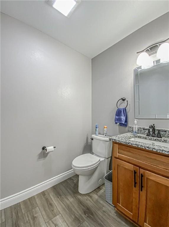 bathroom with hardwood / wood-style floors, vanity, and toilet