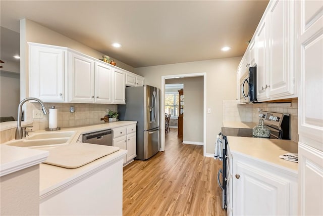 kitchen featuring backsplash, sink, white cabinets, and stainless steel appliances