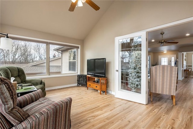 living room featuring ceiling fan, french doors, high vaulted ceiling, and light wood-type flooring