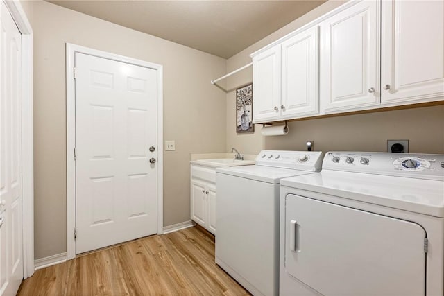 laundry area featuring cabinets, independent washer and dryer, light hardwood / wood-style flooring, and sink