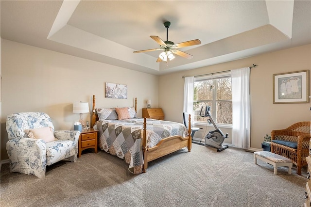 bedroom with carpet, a tray ceiling, and ceiling fan