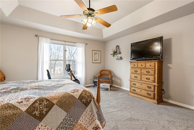 bedroom with carpet flooring, ceiling fan, and a raised ceiling