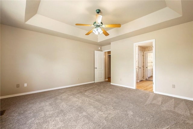 3 Barrhead Ln, Bella Vista, AR 72715 - unfurnished bedroom featuring a tray ceiling, ensuite bath, baseboards, and carpet floors