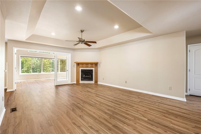 3 Barrhead Ln, Bella Vista, AR 72715 - unfurnished living room with a ceiling fan, a tray ceiling, baseboards, wood finished floors, and a tile fireplace