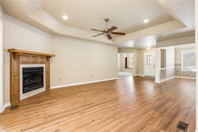 3 Barrhead Ln, Bella Vista, AR 72715 - unfurnished living room featuring baseboards, light wood-style floors, a tray ceiling, and ceiling fan