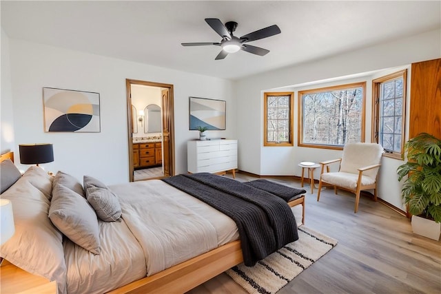 bedroom with connected bathroom, ceiling fan, and light hardwood / wood-style flooring