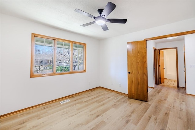 unfurnished bedroom with ceiling fan and light wood-type flooring