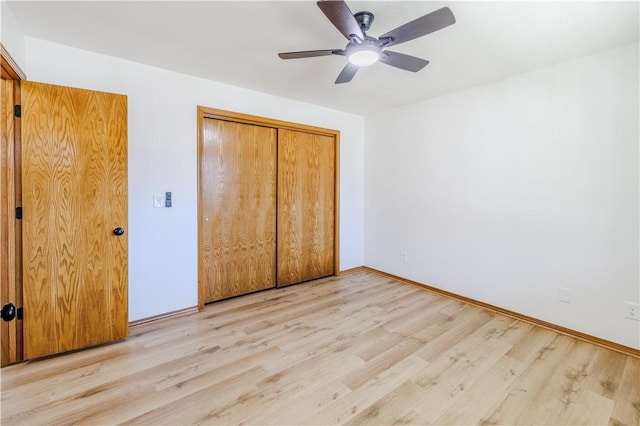 unfurnished bedroom with ceiling fan, light wood-type flooring, and a closet