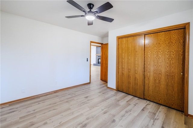 unfurnished bedroom featuring light wood-type flooring, a closet, and ceiling fan